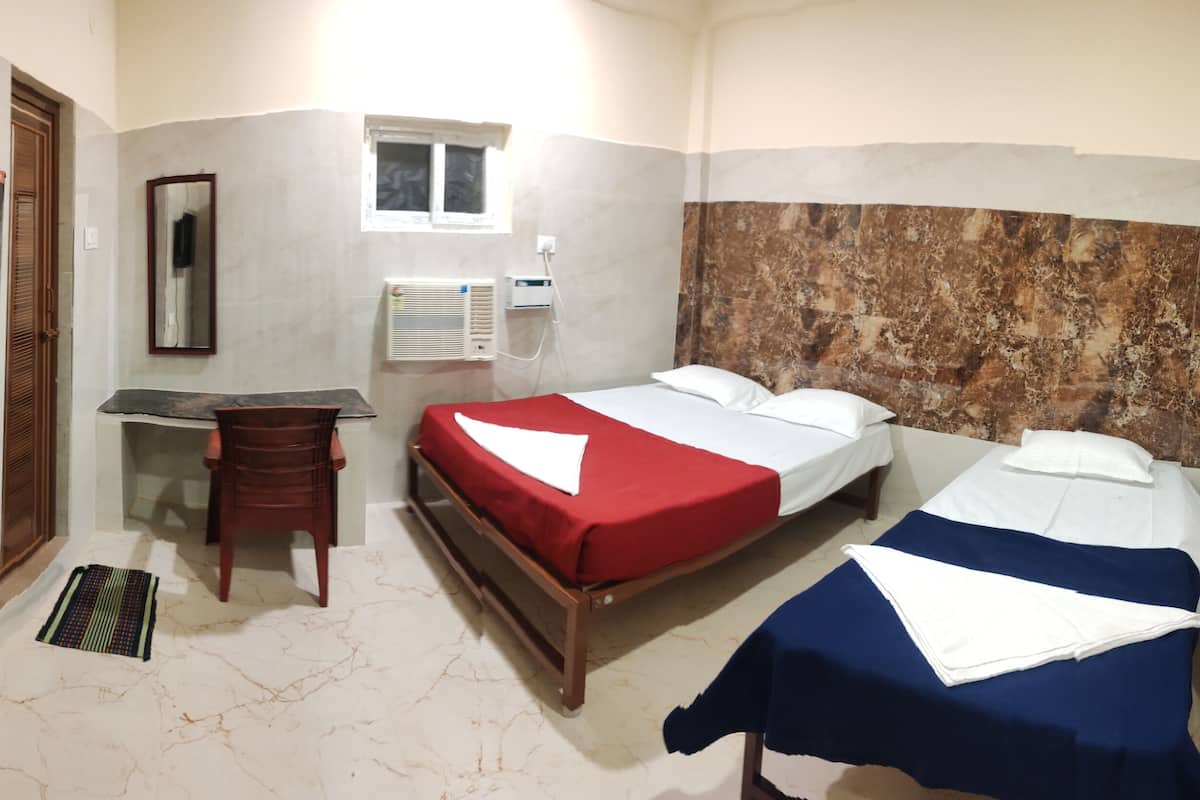 Habitación de hotel con dos camas, un escritorio, una silla, un televisor y una ventana.