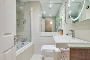 A modern bathroom with a glass-enclosed shower, a white toilet, a vanity with a mirror, and a potted plant. - 2 Bed in Padstow (oc-p00337) (Padstow)
