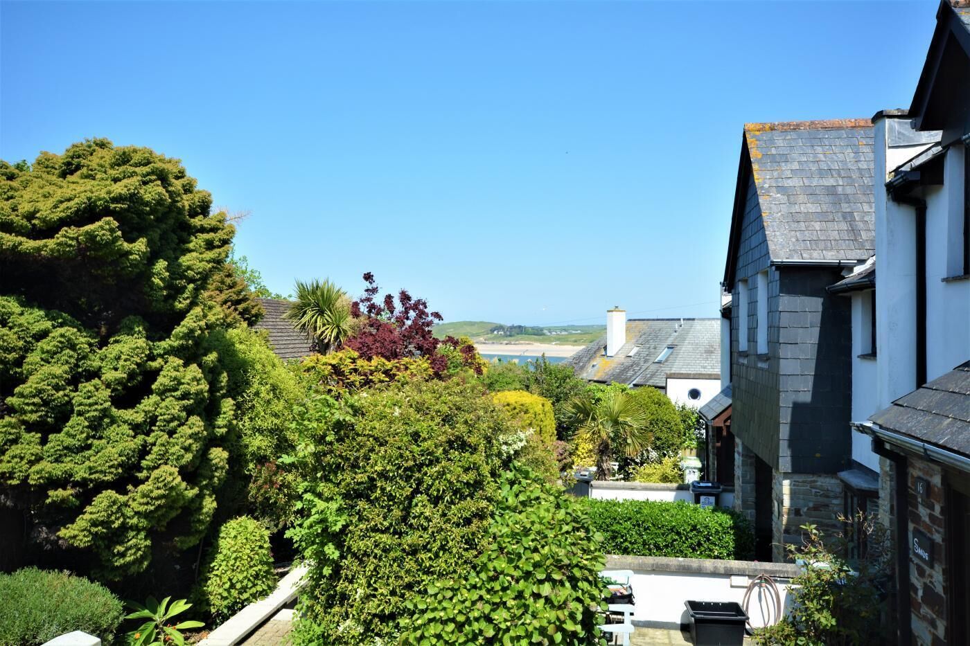 Une propriété située sur la côte, caractérisée par une végétation luxuriante, un bâtiment en pierre et une vue sur la mer.