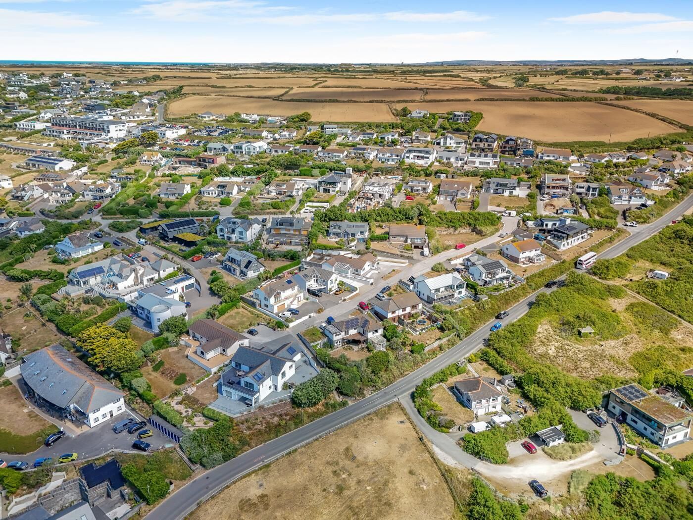 Un quartier résidentiel composé de maisons, de routes et de champs ouverts.