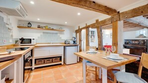 A modern kitchen with a wooden island, white cabinets, and a tiled backsplash. - 2 Bed in Walsham-le-Willows (oc-gabpla) (Walsham le Willows)