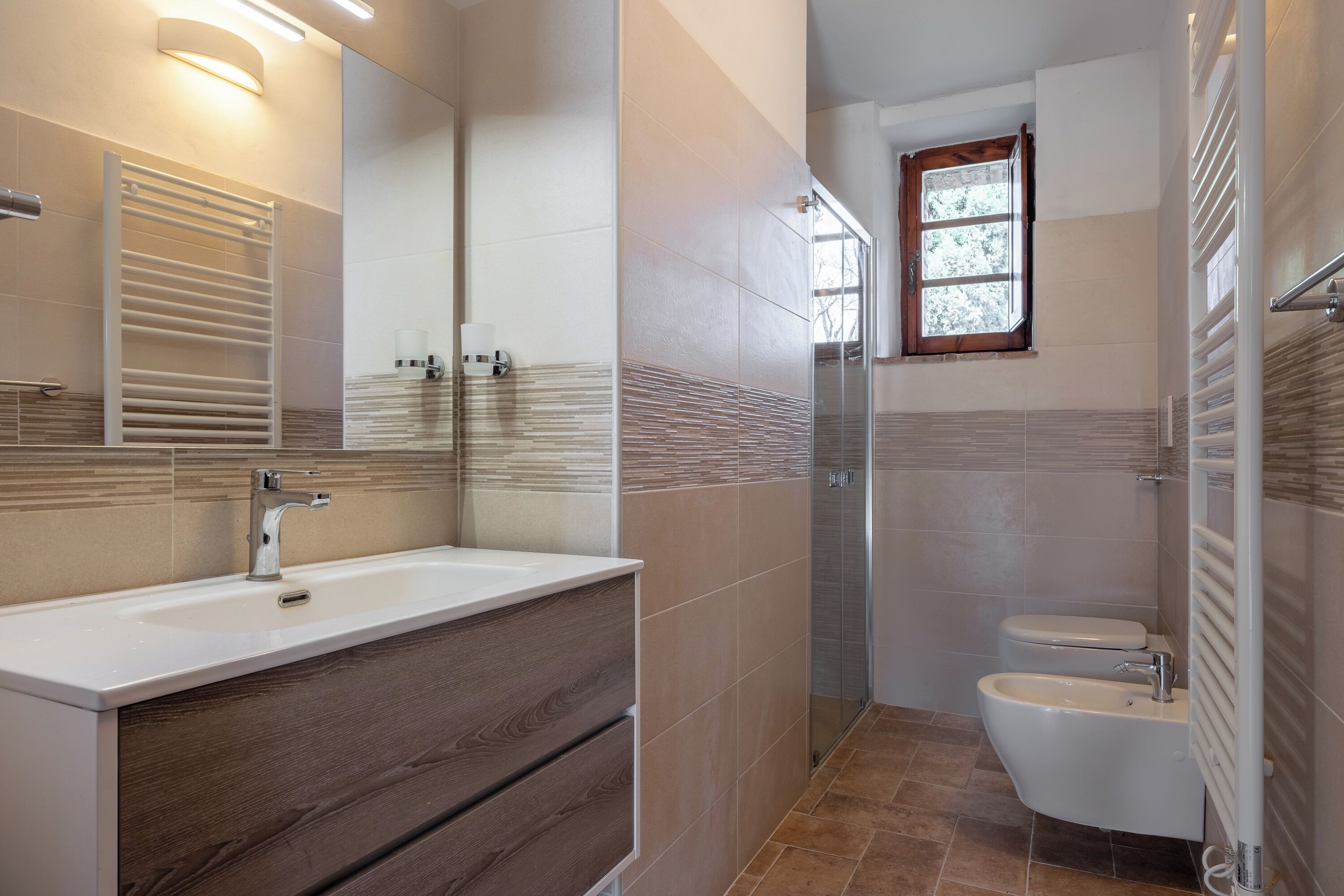 Ein modernes Badezimmer mit Waschtisch, Dusche und Toilette.