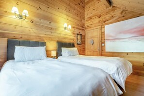 A double room with two beds, wooden walls, and a painting on the wall. - 3 Bed in Wadebridge (oc-p00104) (Little Petherick)