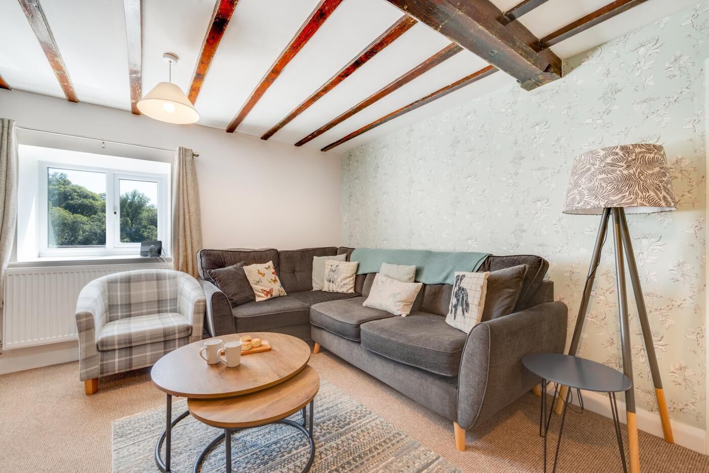 A cozy living room with a sofa, armchair, coffee table, and floor lamp.