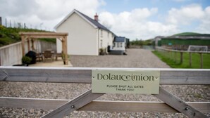 A wooden gate with a sign that reads "Dolaucourt" and "PLEASE SHUT ALL GATES THANK YOU!" in front of a white building with a grey roof. - 4 Bed in Welshpool (oc-wab267) (Welshpool)