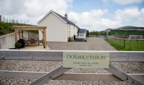 A wooden gate with a sign that reads "Dolaucourt" and "PLEASE SHUT ALL GATES THANK YOU!" in front of a white building with a grey roof. - 4 Bed in Welshpool (oc-wab267) (Welshpool)