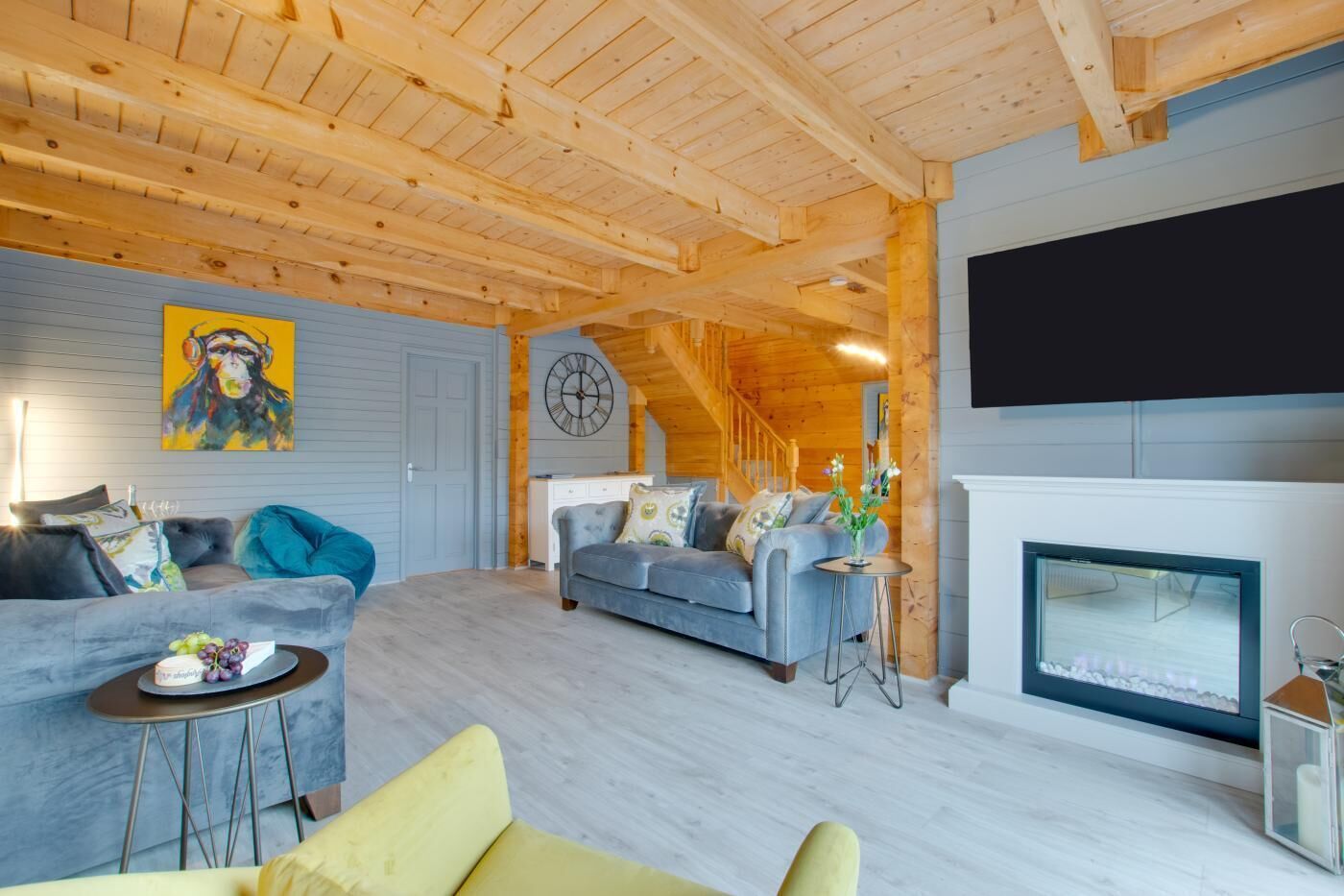 Ein Holzinnenraum mit einer Couch, einem kleinen Tisch, einem Fernseher und einem Kamin.