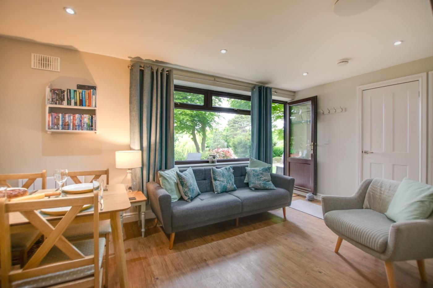 A living room with a sofa, a dining table, and a bookshelf.