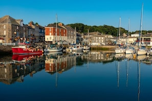 A harbor with boats docked, stone buildings, and a clear sky.