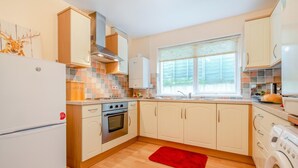 A compact kitchen with a refrigerator, oven, and washing machine. - 1 Bed in Wadebridge (oc-p00232) (Wadebridge)