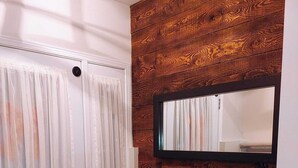 Una habitación con paneles de madera, un banco y una puerta con un espejo encima.