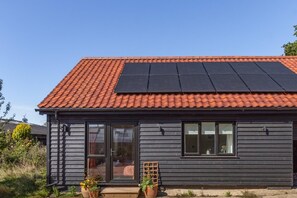 A house with a red-tiled roof, a black awning, and solar panels. - 2 Bed in Elmswell (oc-t32377) (Elmswell)
