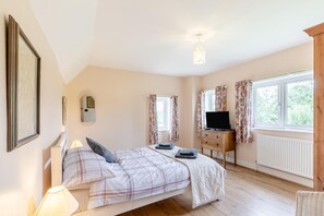 A bedroom with a bed, a TV on a wooden cabinet, and a window with curtains. - 3 Bed in Hastings (oc-h32649) (Three Oaks)