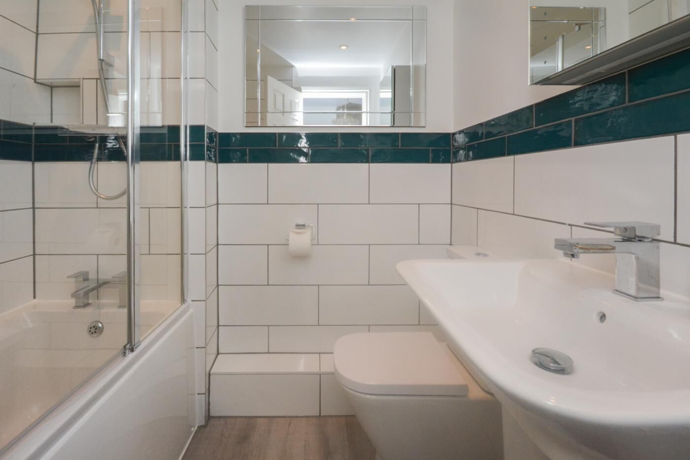 A modern bathroom with a glass shower enclosure, a white sink, and a toilet.