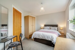 A bedroom with a bed, bedside tables, a desk, a chair, a wardrobe, and a hanging light fixture. - 2 Bed in Crook (oc-s32614) (Crook)