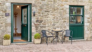 Een stenen gebouw met een bord waarop 'Stable Cottage' staat.