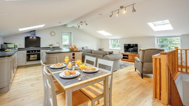 Ruime loft met keuken, eetgedeelte en woongedeelte, met dakramen en een modern design.