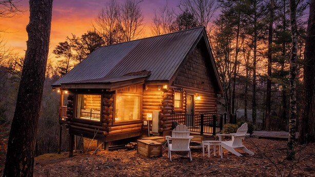 A log cabin with a porch, two Adirondack chairs, and a wooden bench. - Hot Tub, Views, & True Smoky Mountain Charm! (Sevierville)