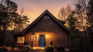 A log cabin with a front porch, a blue door, and a small porch area with a bench. - Hot Tub, Views, & True Smoky Mountain Charm! (Sevierville)