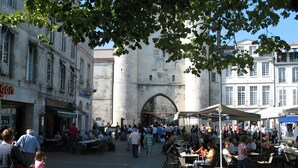 A bustling outdoor market with people and tables, surrounded by historic buildings. - Gîte de l'érable, 5 min from La Rochelle (Périgny)