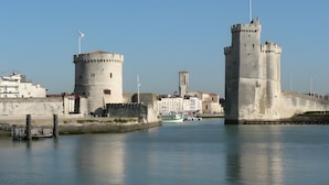 A historic waterfront with two prominent towers, a bridge, and a boat dock. - Gîte de l'érable, 5 min from La Rochelle (Périgny)