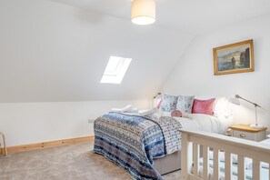 A bedroom with a bed, a nightstand, a lamp, a painting, and a window. - 3 Bed in Ventnor (oc-o32663) (Chale)