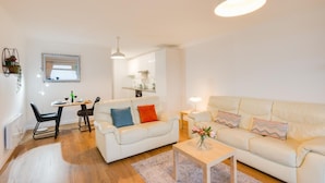 Una sala de estar moderna con un sofá, una mesa de centro y un comedor con una mesa y sillas.