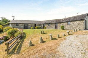 A stone building with a gravel courtyard, stone bollards, and a wooden fence. - 3 Bed in St Columb (oc-trembl) (Saint Mawgan)