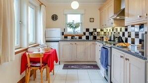 Une cuisine moderne avec des meubles en bois, un four encastré et une fenêtre offrant une belle vue.
