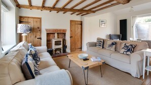 A cozy living room with a fireplace, a sofa set, and a wooden ceiling. - 3 Bed in Holt (oc-2150) (Holt)