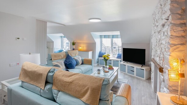 Een moderne woonkamer met een bank, salontafel en televisie.