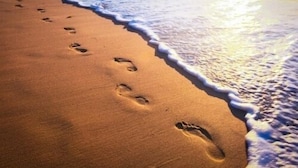 A sandy beach with footprints leading towards the water. - 3 Bed in Llanfynydd (oc-pw9215) (Llanfynydd)