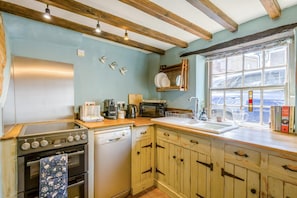 Une cuisine avec des meubles en bois, une cuisinière, un four à micro-ondes et une fenêtre donnant sur un beau paysage.