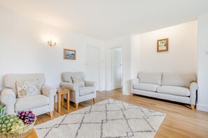 Ein geräumiges Wohnzimmer mit zwei Sofas, einem Couchtisch und einem Teppich.