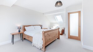 A bedroom with a wooden bed, a bedside table, a lamp, and a skylight. - 4 Bed in St. Peters (oc-h32665) (Broadstairs)