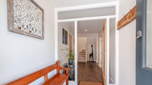 A hallway with a wooden bench, a giraffe statue, and a staircase leading to another room. - 4 Bed in St. Peters (oc-h32665) (Broadstairs)