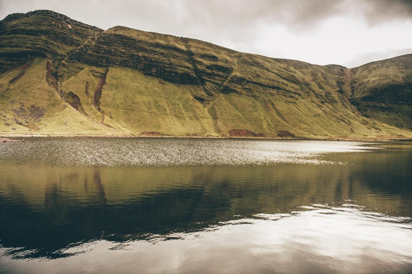 A calm lake with a mountain in the background.