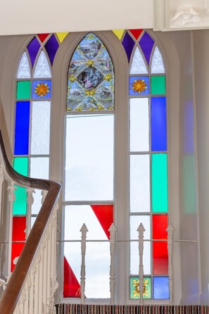A stained glass window with geometric patterns and a central depiction of a nativity scene. - 2 Bed in Padstow (oc-p00499) (Porthcothan Bay)