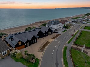 A coastal residential area with modern houses, a road, and a beach. - 5 Bed in Bexhill-on-Sea (oc-c32704) (Bexhill-on-Sea)