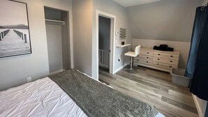 A bedroom with a bed, a desk, a chair, and a dresser. - Downtown Retreat Moncton (Moncton)