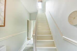 A staircase with white walls and a clock on the right. - 4 Bed in Matlock Bath (oc-r32432) (Matlock Bath)