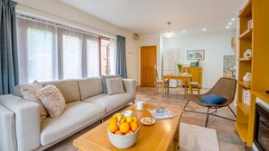 Uma sala de estar moderna com sofá, mesa de centro e área de jantar.