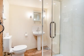 A modern bathroom with a toilet, sink, and glass shower enclosure. - 4 Bed in St. Nicholas South Elmham (oc-o32397) (All Saints South Elmham)