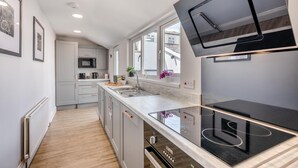A modern kitchen with a built-in oven, a microwave, and a large window. - 3 Bed in Amble (oc-k32746) (Amble)