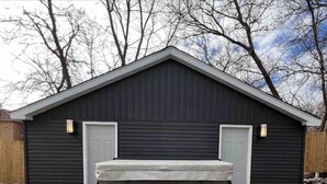 A black shed with two doors and a hot tub in front. - Downtown Oasis Moncton (Moncton)