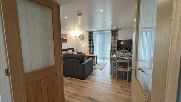 A modern living room with a sofa, a dining table, and a TV. - 2 Bed in Tankerness (oc-q32730) (Tankerness)
