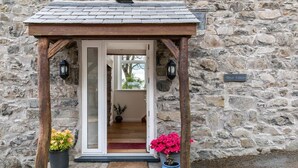 Un bâtiment en pierre doté d’un porche en bois, d’une porte et d’une enseigne sur laquelle on peut lire « Bryn Eithin ».