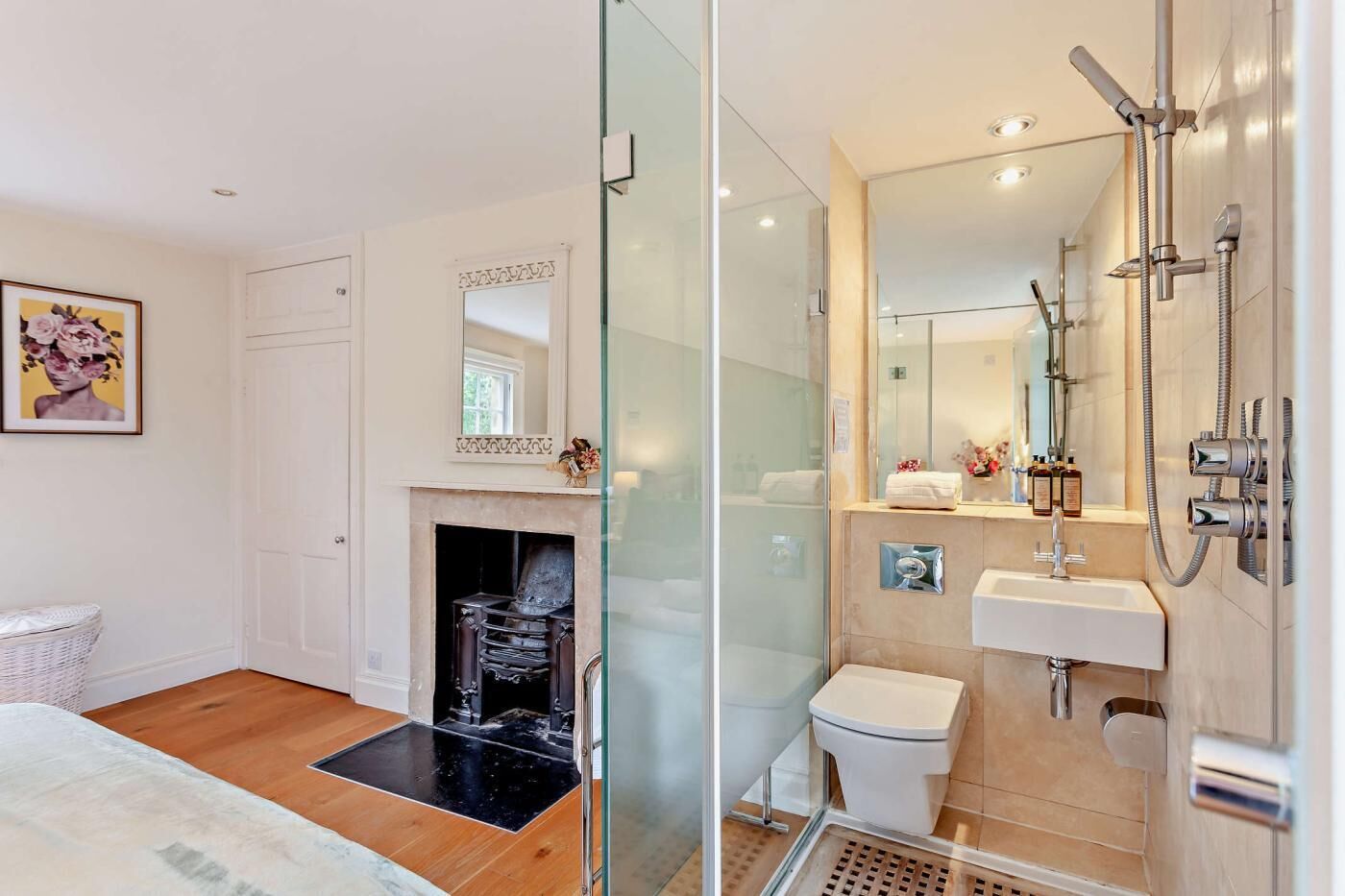 A modern bathroom with a glass shower enclosure, a white sink, and a toilet.