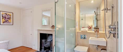A modern bathroom with a glass shower enclosure, a white sink, and a toilet.