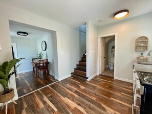 A modern kitchen with a built-in oven and a dining area with a table and chairs. - Downtown Urban Elegance (Moncton)